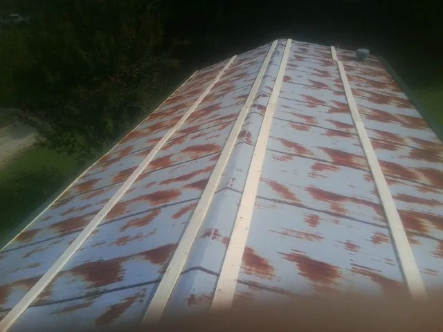 Rusted metal roof panels with new wood purlins before replacement — Storm Damage Roof Repair in Frenchglen by Roofing Brothers