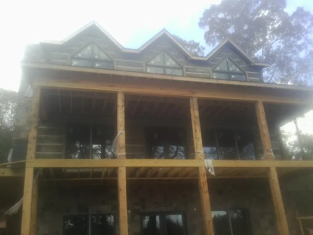 Dormers and porch framing on a large log home under construction — Roof Coating work by our crew in Frenchglen
