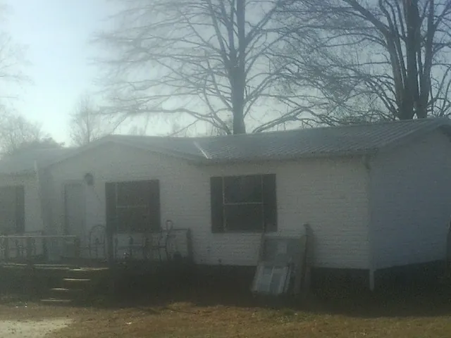 New metal roof on a white painted brick home on a foggy morning in Frenchglen