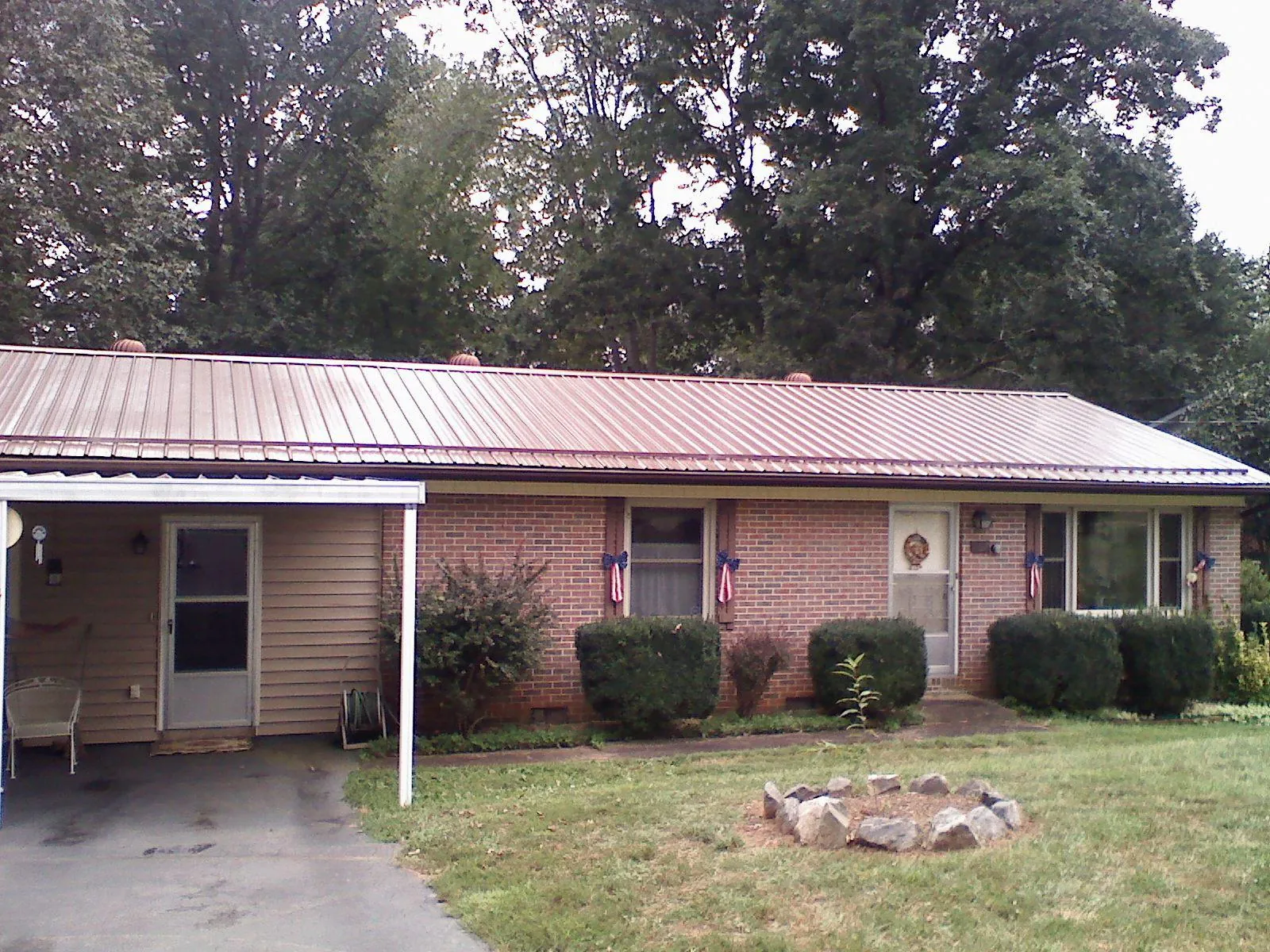 Bronze metal roof and carport on a brick ranch home — Roof Repair work by our crew in Frenchglen