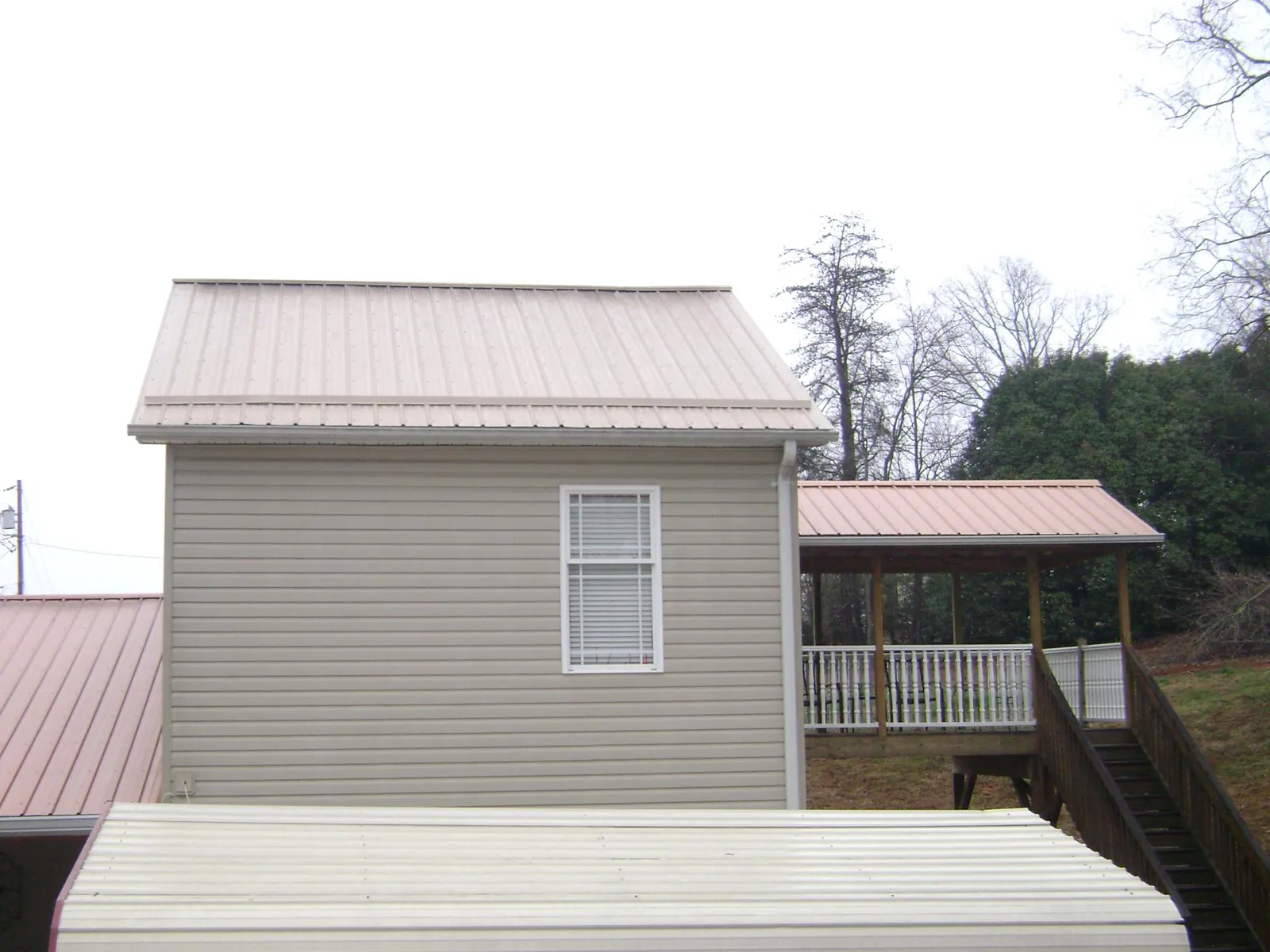 Tan metal roofs on a two story addition and attached porch, from a Roof Replacement job in Frenchglen